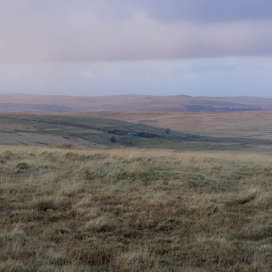 Image of grassy moorlike landscape with pale pastel coloured clouds by Daniel Dayment BA Hons Photography grad from the class of 2022