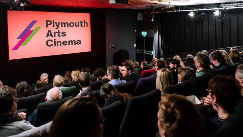 A busy audience watching a presentation at Plymouth Arts Cinema