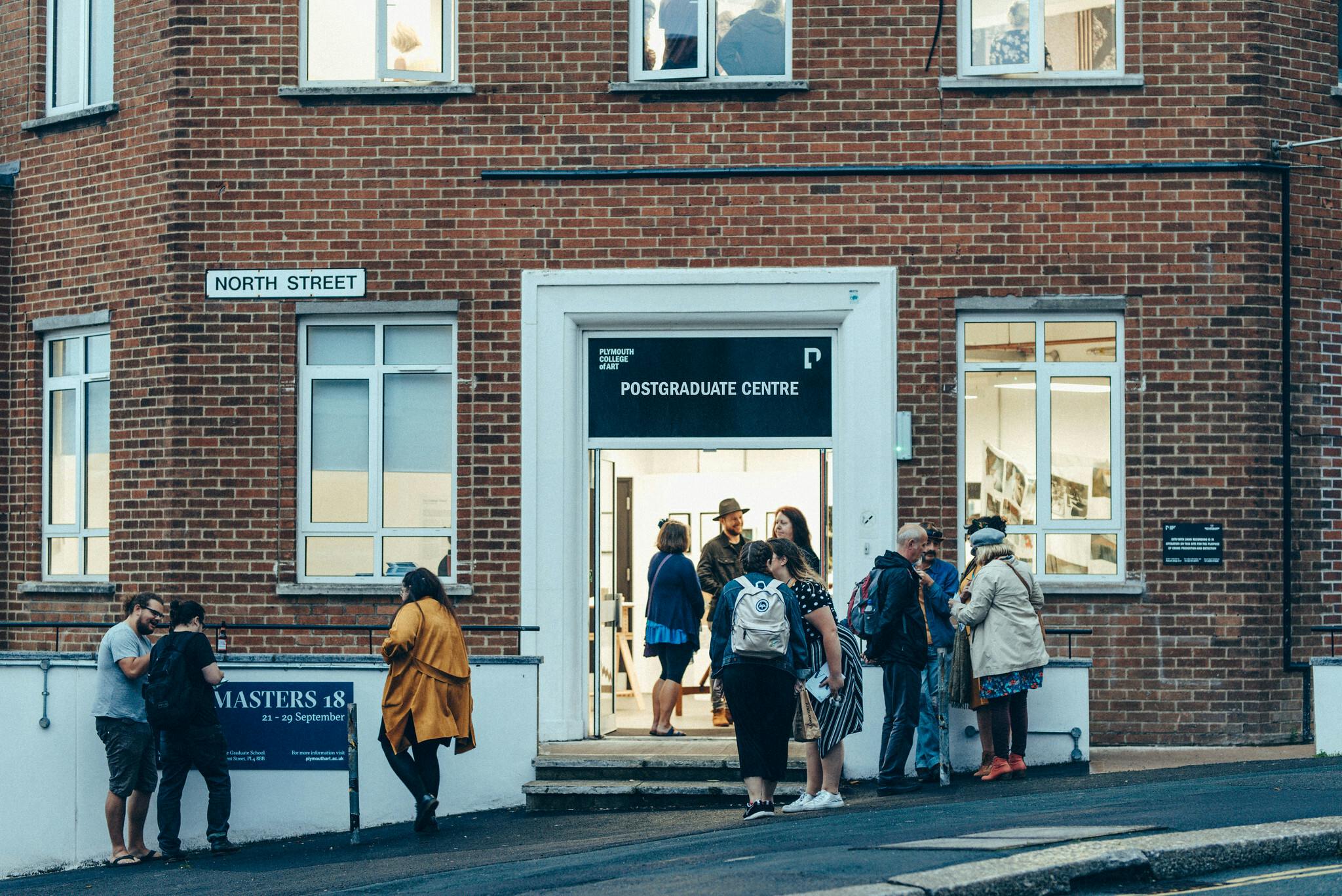 Masters students and their friends and family arrive at the postgraduate centre, a red-brick corner building, to celebrate their achievements.