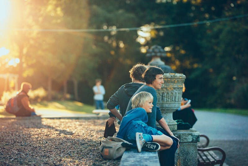 Making Futures 2017 an adult and child sit in the afternoon sun at Mount Edgcumbe Photo by Dom Moore