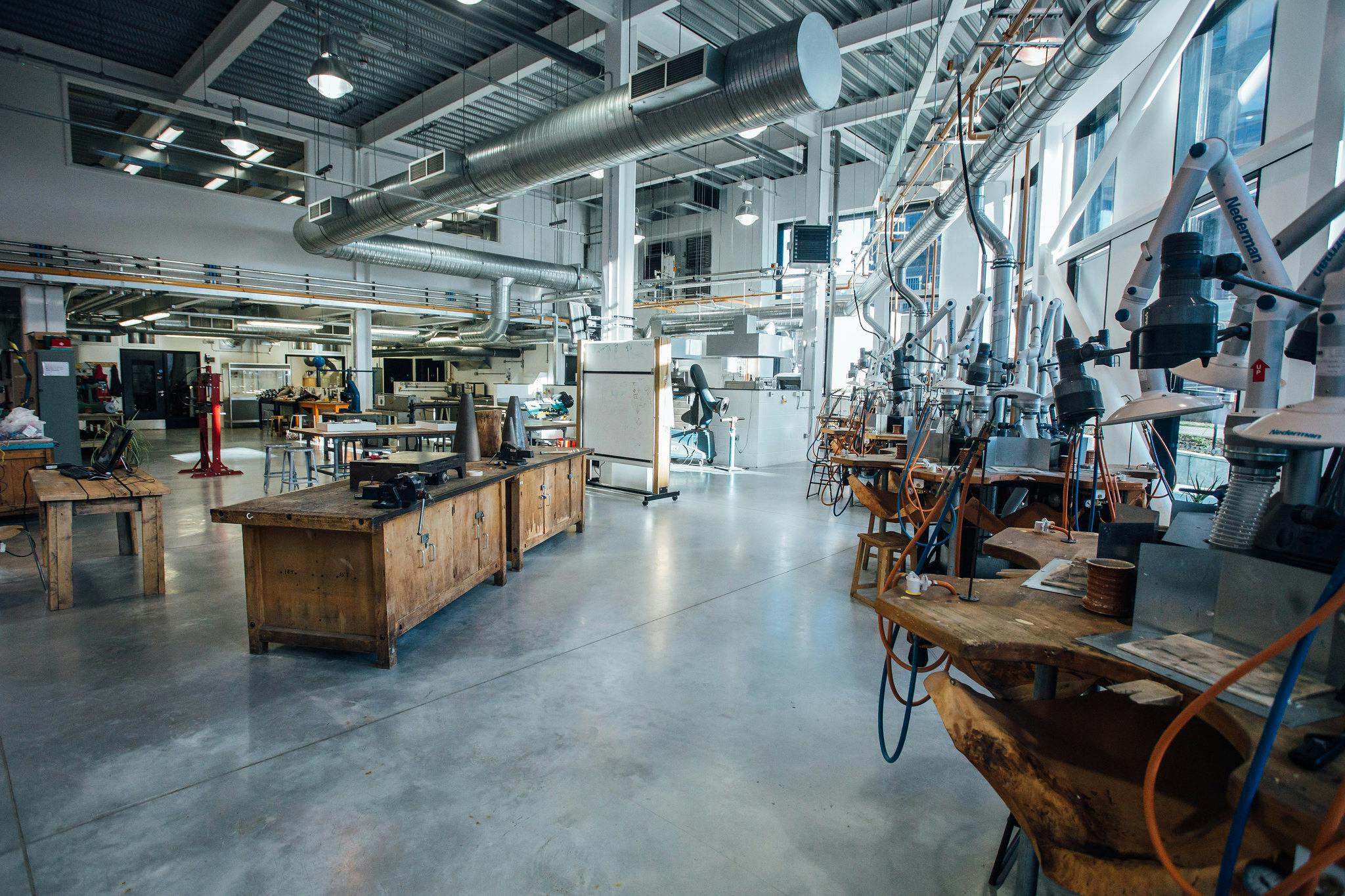 Our Jewellery Studio is a large, open space with high ceilings and full length windows to flood the workshop with natural light. Along the windows sits jewellery work stations with tools.